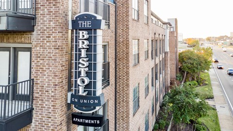 a sign for the tribeca pullman apartments hangs on the side of a brick building